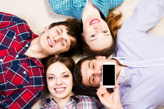 four young people are together, the young man pressed his lips to the phone