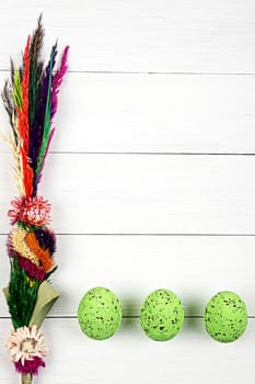 Easter Palm and easter eggs on a white plank