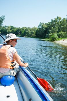 Happy woman paddling a kayak on the river, enjoying a lovely summer day