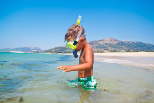 Summer vacation - Portrait of happy boy in face masks and snorkels, sea in background.