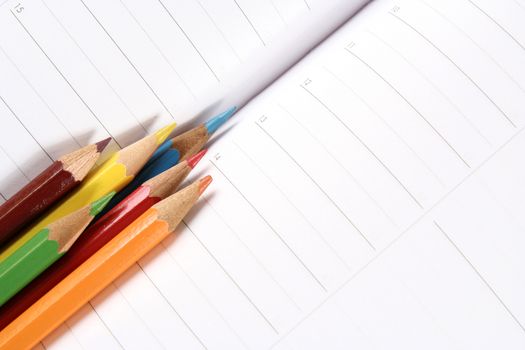 Close-up of color pencils and agenda