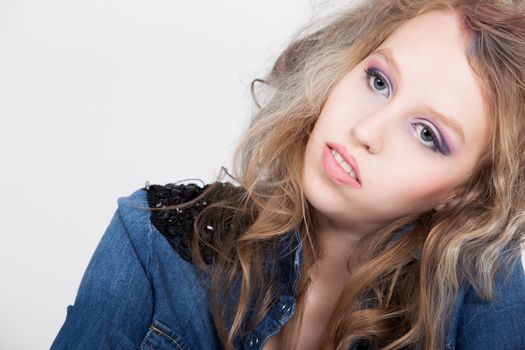 Young tough blond teenage girl with jeans blouse on a white background