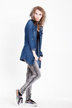 Young tough blond teenage girl with jeans blouse on a white background