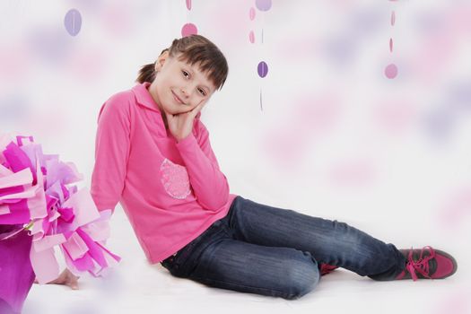 Smiling teenage girl sitting in pink decoration