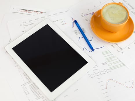 Tablet pc, cup of coffee and paper with graphs. Business concept