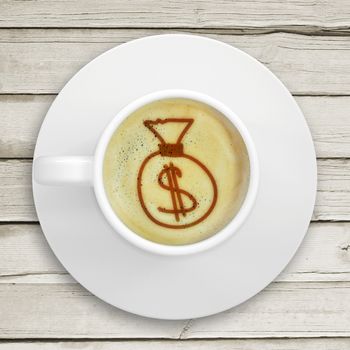 Cup of coffee standing on a wooden surface. Picture of the bag of money in the coffee crema. top view
