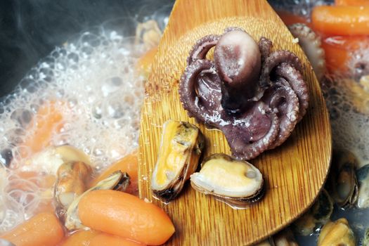 Seafood cooked with vegetables in a pan.