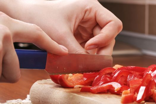 Chopping pepper with knifein small pieces.