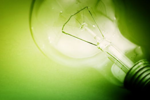 Background with lit lightbulb. Isolated on green