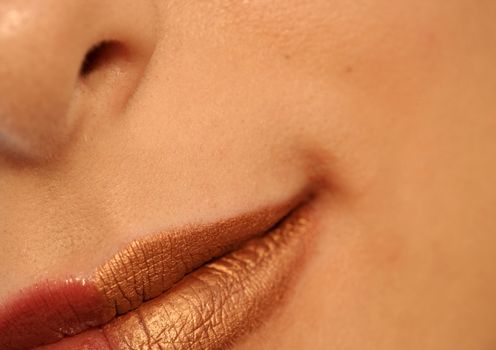 Macro image of bright lips. Red and gold lipstik