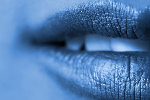 Macro blur image of bright lips -gold lipstik