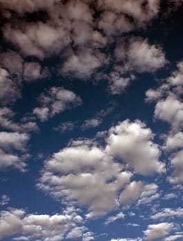 A background of bright white clouds on a blue sky