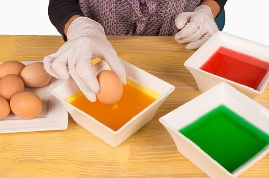 Hands with gloves getting ready to dye Easter eggs