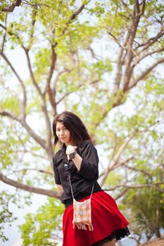 Asian women black shirt standing under a tree. Happy smiling relaxing in the park.