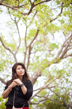 Asian women black shirt standing under a tree. Looking forward