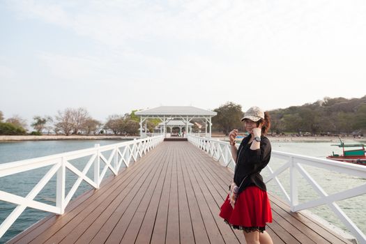 Asian women black shirt. Standing in a white wooden bridge. Beside the sea