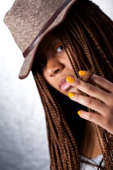 portrait of a girl in a hat with a cigar in his fingers, focus on hand