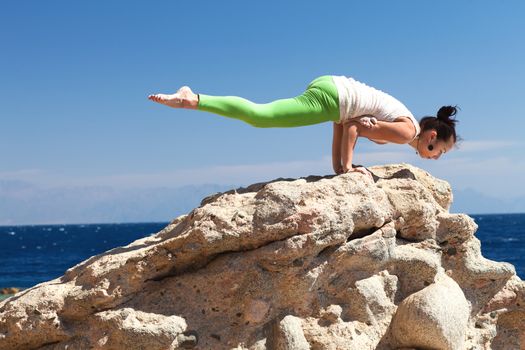 girl doing yoga on the beach