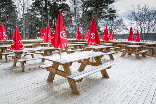 Red parasols with icecream logos outdoors in the spring, Kanaan minigolf cafe, Stockholm, Sweden.