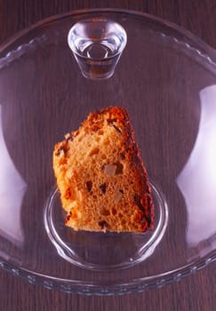 Chocolate cake under glass and over a stand