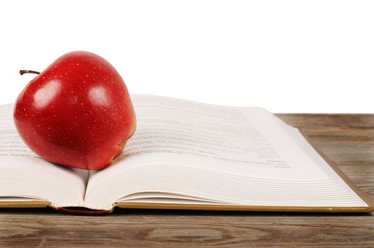 Open book with apple isolated on white