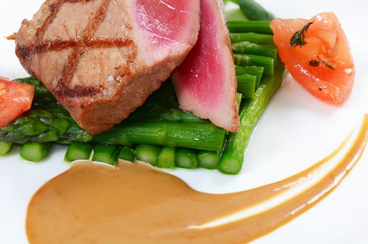 Tuna a grill with an asparagus close-up