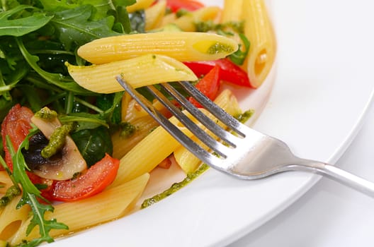 pasta with vegetables and salad close up