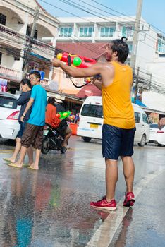 Phuket, Thailand - April 13, 2014: Tourist and residents celebrate Songkran Festival, the Thai New Year by splashing water to each others on Patong streets. 
