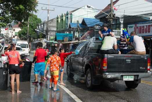 Phuket, Thailand - April 13, 2014: Tourist and residents celebrate Songkran Festival, the Thai New Year by splashing water to each others on Patong streets. 