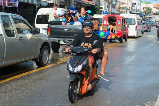 Phuket, Thailand - April 13, 2014: Tourist and residents celebrate Songkran Festival, the Thai New Year by splashing water to each others on Patong streets. 