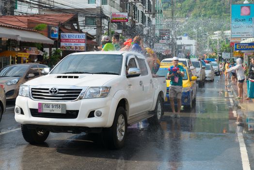 Phuket, Thailand - April 13, 2014: Tourist and residents celebrate Songkran Festival, the Thai New Year by splashing water to each others on Patong streets. 