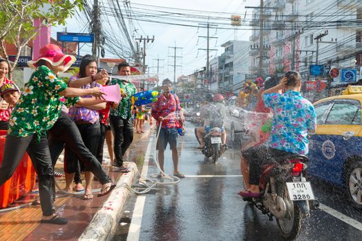 Phuket, Thailand - April 13, 2014: Tourist and residents celebrate Songkran Festival, the Thai New Year by splashing water to each others on Patong streets. 