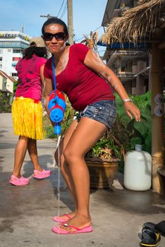 Phuket, Thailand - April 13, 2014: Thay woman with water gun celebrate Songkran Festival, the Thai New Year by splashing water to each others on Patong streets. 