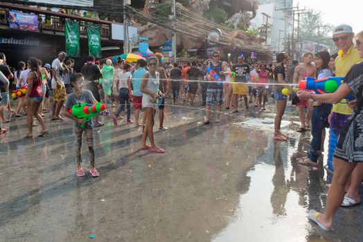 Phuket, Thailand - April 13, 2014: Tourist and residents celebrate Songkran Festival, the Thai New Year by splashing water to each others on Patong streets. 