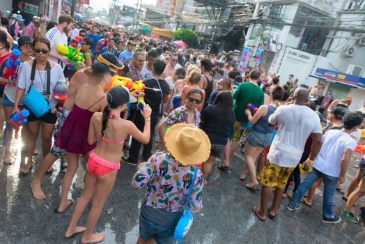 Phuket, Thailand - April 13, 2014: Tourists and residents celebrate Songkran Festival, the Thai New Year by splashing water to each others on Patong streets. 