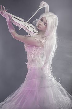 Fantasy concept, sensual young woman with vintage white violin