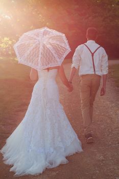 Bride and groom walking off into sunset after wedding ceremony