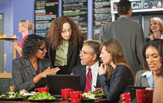 Business people in serious discussion during lunch in cafe