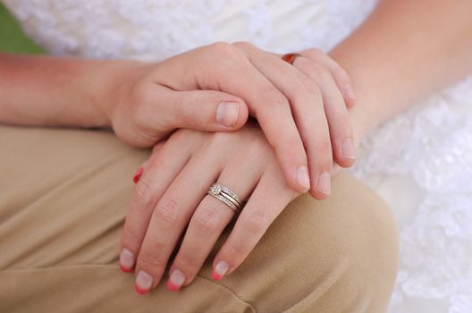 Bride and groom holding hands with marriage wedding ring