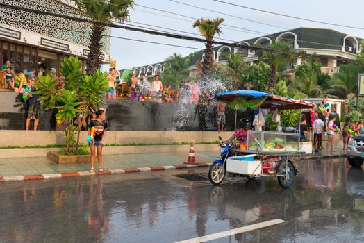 Phuket, Thailand - April 13, 2014: Tourists and residents celebrate Songkran Festival, the Thai New Year by splashing water to each others on Patong streets. 