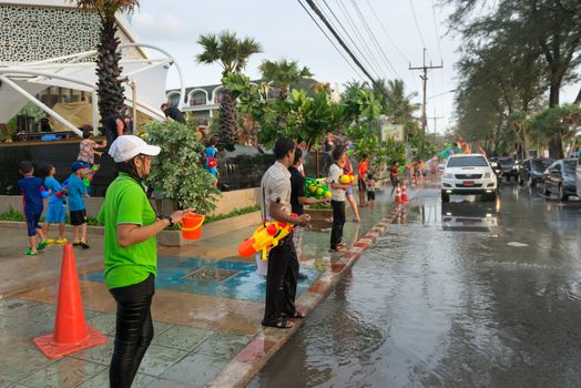 Phuket, Thailand - April 13, 2014: Tourists and residents celebrate Songkran Festival, the Thai New Year by splashing water to each others on Patong streets. 