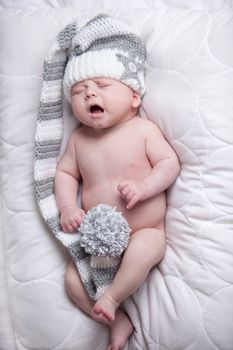 Little baby boy is having a relaxing time on his white blanket