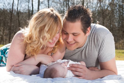 Young family is having  nice time with their baby on a sunny day