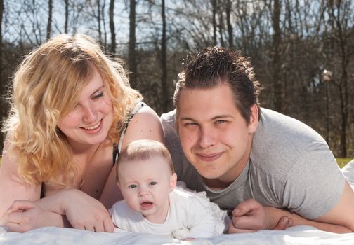 Young family is having  nice time with their baby on a sunny day