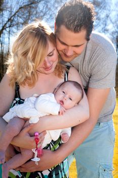 Young family is having  nice time with their baby on a sunny day