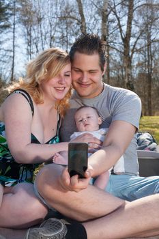 Young family is taking a selfie picture with their smartphone