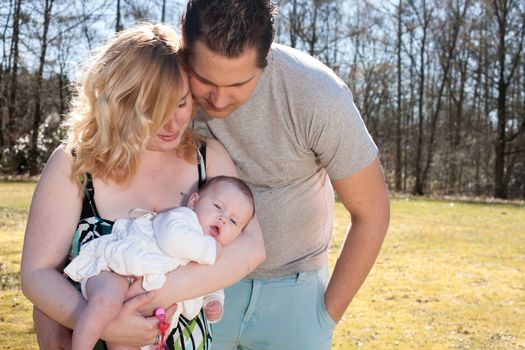 Young family is having  nice time with their baby on a sunny day