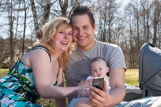 Young family is taking a selfie picture with their smartphone