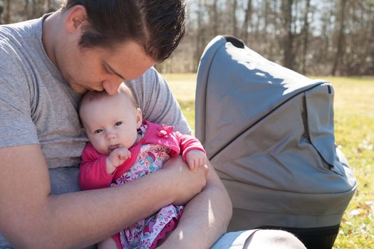 Young father is having some nice time with his baby on a sunny day