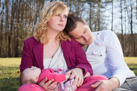 Young family is having  nice time with their baby on a sunny day